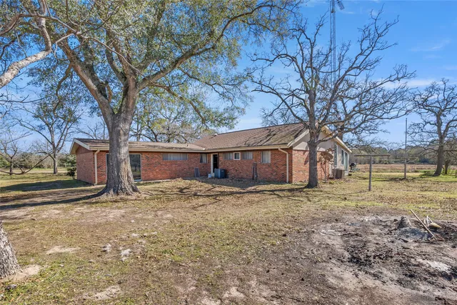 a view of a house with backyard and trees
