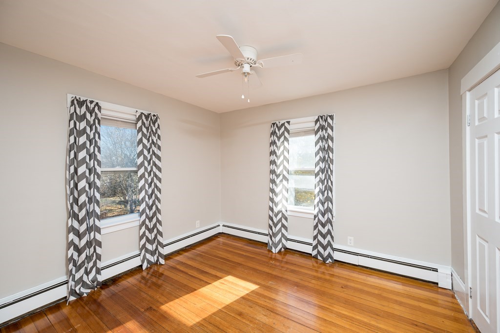 48 Bates Street Hull, MA 02045 - Photo 18 of 31 an empty room with wooden floor staircase and windows
