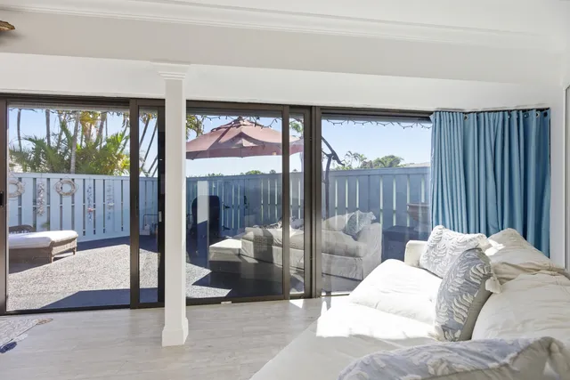 a kitchen with stainless steel appliances kitchen island granite countertop a dining table chairs and a refrigerator