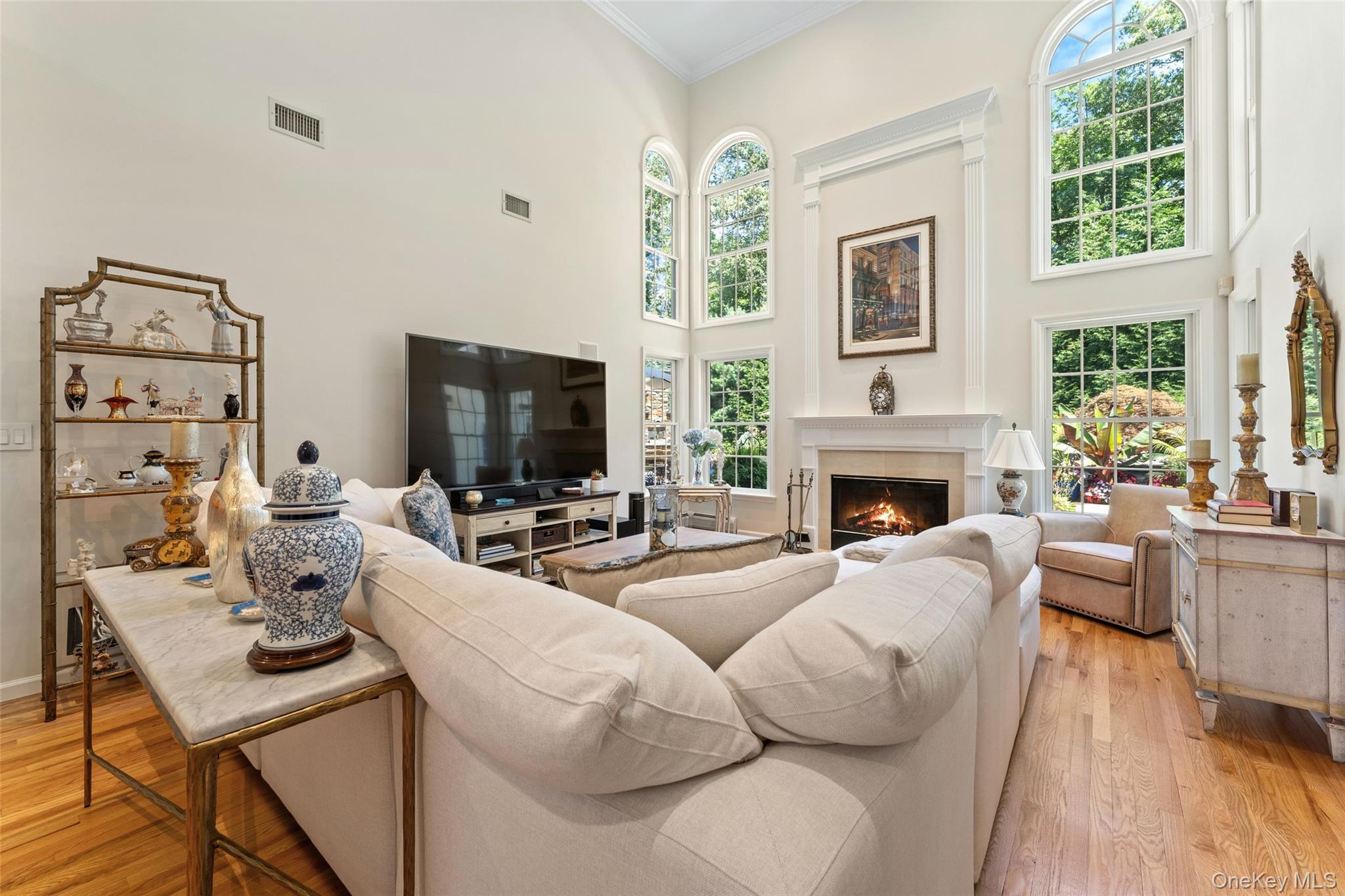 22 Perrin's Peak Road Stony Point, NY 10980 - Photo 26 of 47 Living area featuring light wood-style floors, crown molding, a warm lit fireplace, and healthy amount of natural light