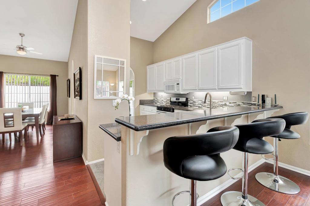 1205 Rancho Pacifica Place Vista, CA 92084 - Photo 16 of 42 a kitchen with a dining table chairs and microwave