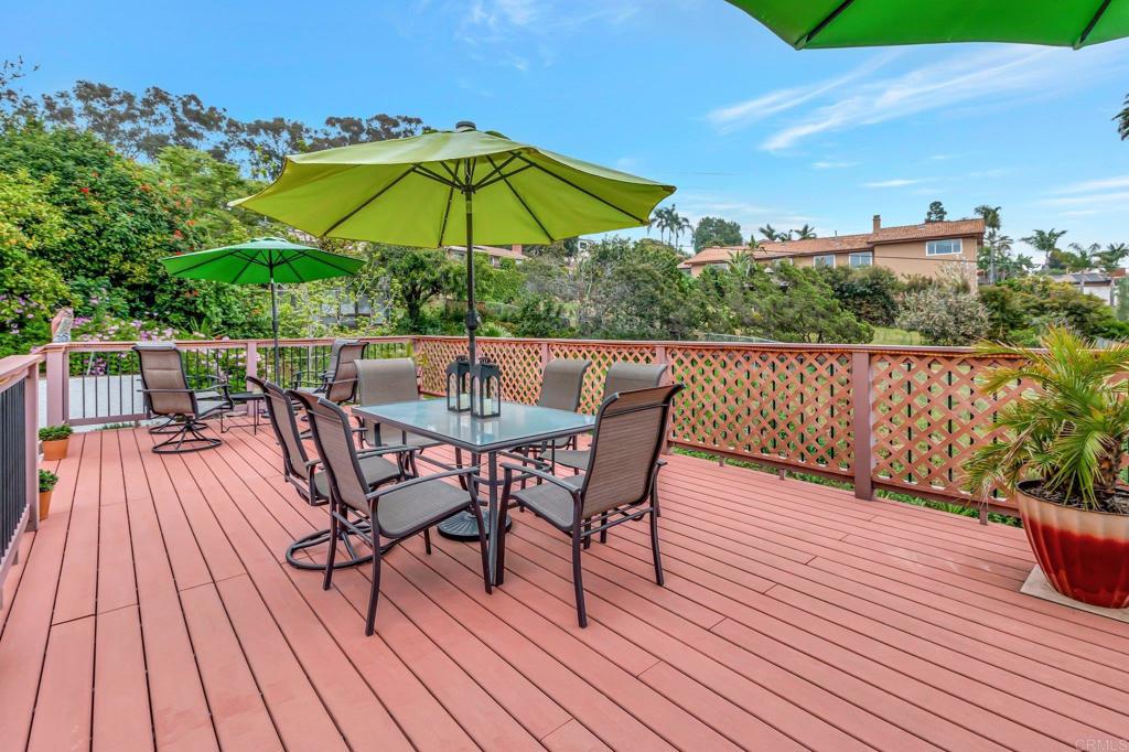 1205 Rancho Pacifica Place Vista, CA 92084 - Photo 19 of 42 a view of deck with dinning table and chair under an umbrella with wooden floor