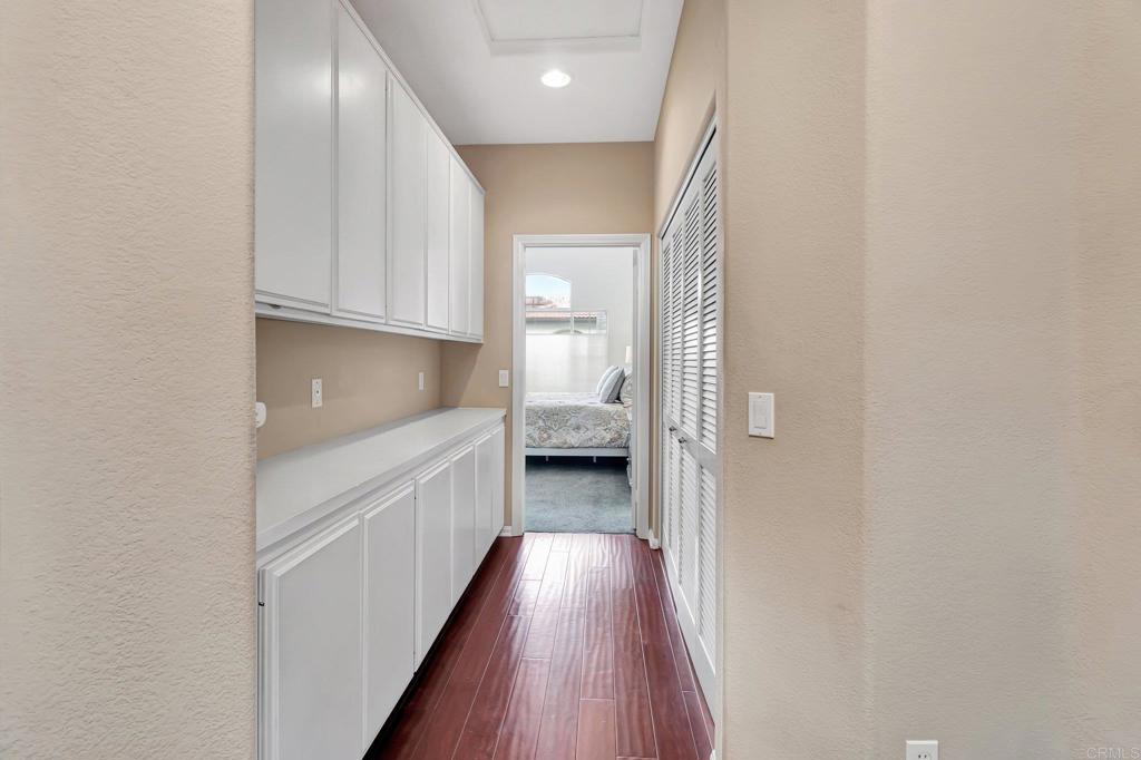 1205 Rancho Pacifica Place Vista, CA 92084 - Photo 32 of 42 a kitchen with white cabinets and wooden floor