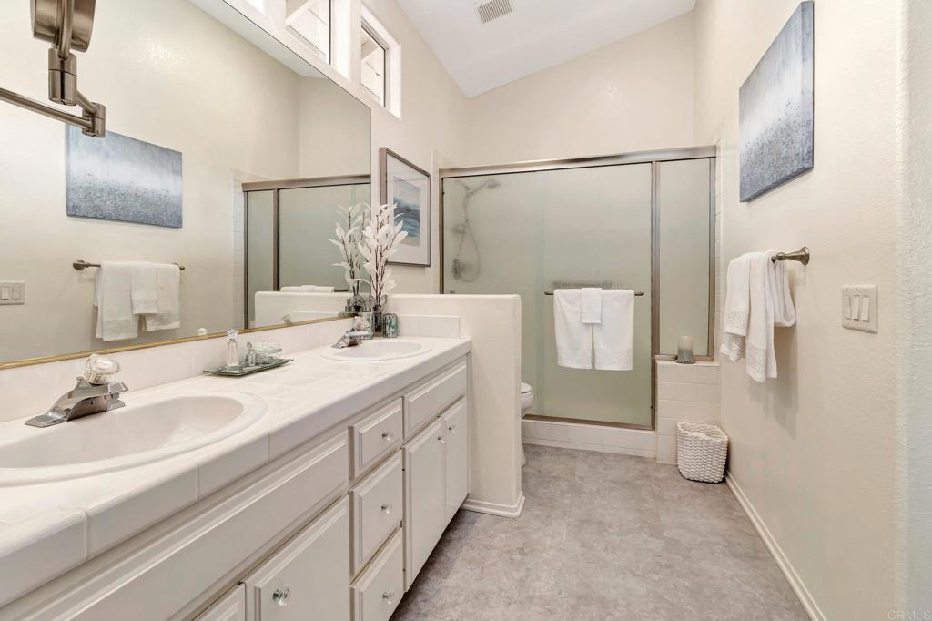 1205 Rancho Pacifica Place Vista, CA 92084 - Photo 34 of 42 a bathroom with a double vanity sink mirror and shower