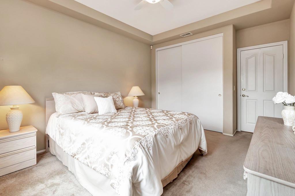 1205 Rancho Pacifica Place Vista, CA 92084 - Photo 41 of 42 a spacious bedroom with a bed and a lamp
