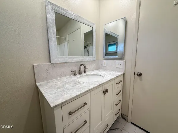 a bathroom with a granite countertop sink and a mirror