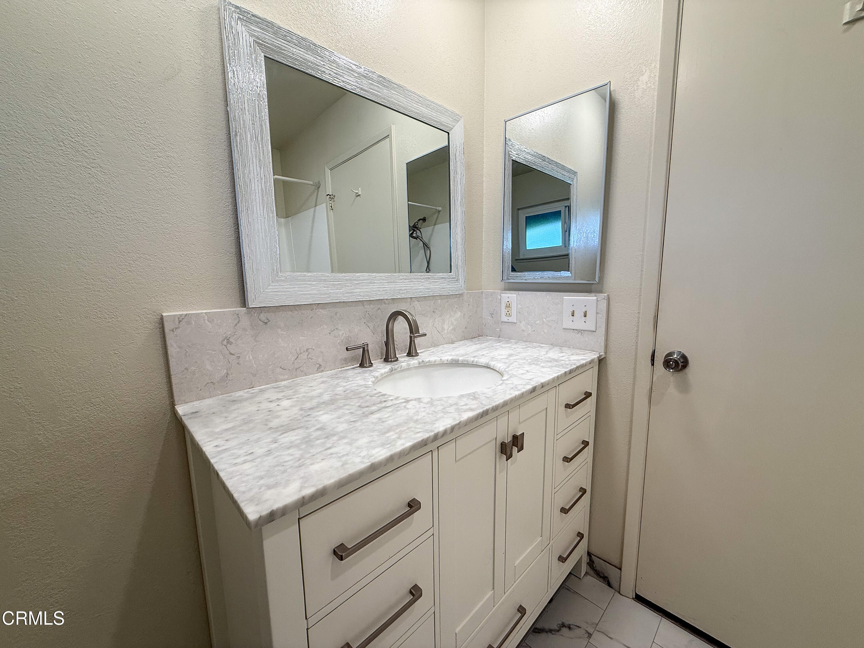1730 West Hemlock Street Oxnard, CA 93035 - Photo 17 of 25 a bathroom with a granite countertop sink and a mirror