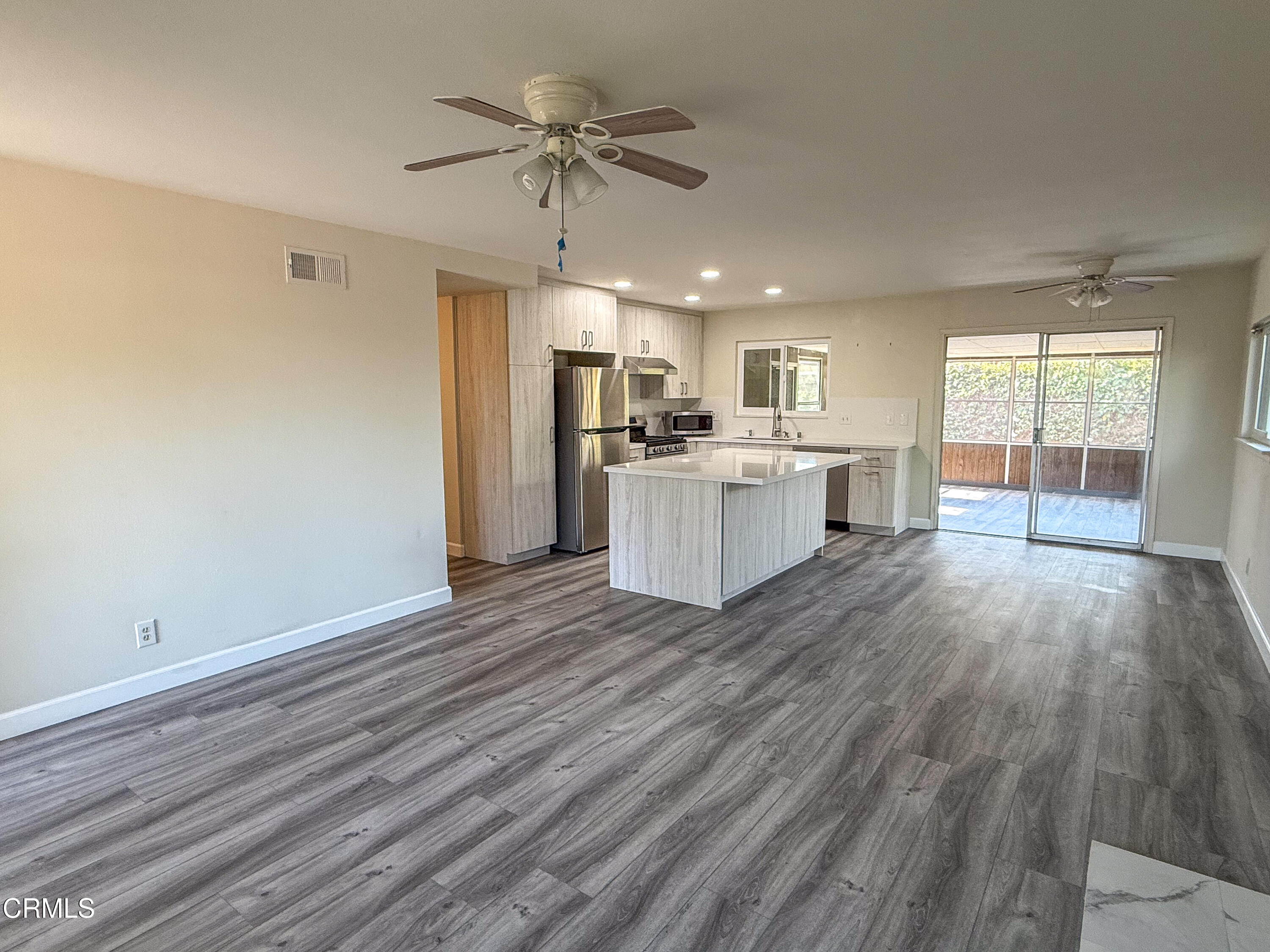 1730 West Hemlock Street Oxnard, CA 93035 - Photo 5 of 25 a view of a kitchen with a sink and dishwasher with wooden floor