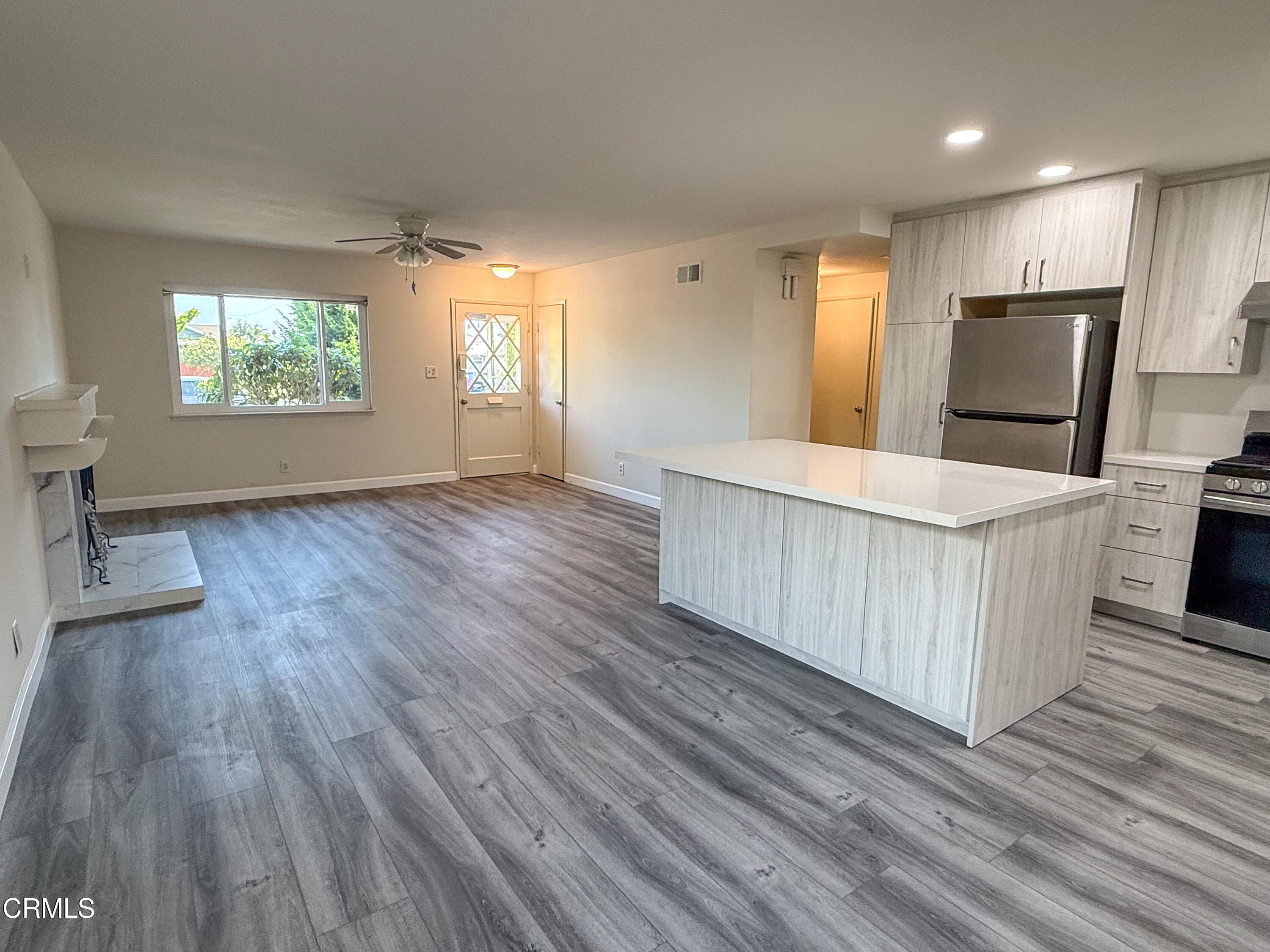 1730 West Hemlock Street Oxnard, CA 93035 - Photo 6 of 25 an empty room with wooden floor and windows