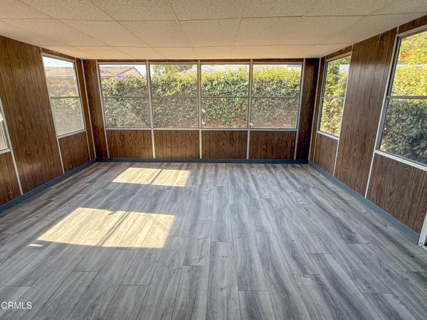 a view of wooden floor in an empty room with a window