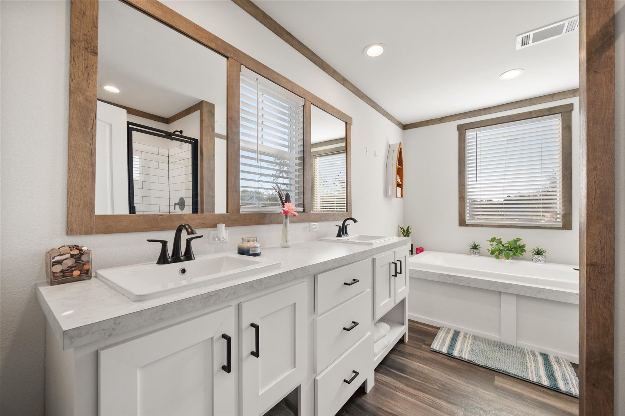 16857 Fm 639 Road East Purdon, TX 76679 - Photo 26 of 38 Full bath with a bath, double vanity, a stall shower, dark wood finished floors, and crown molding