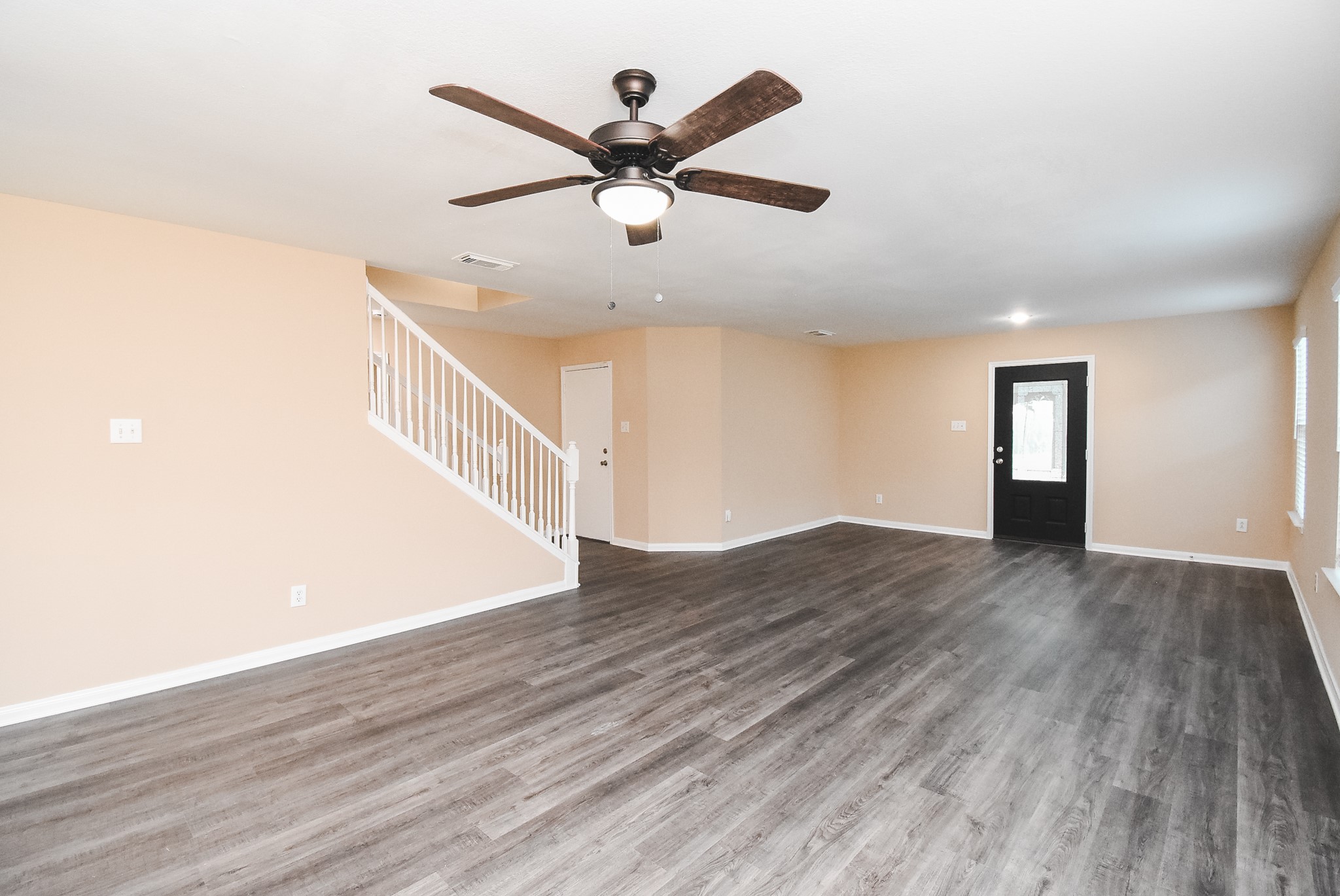 20815 Baronsledge Lane Katy, TX 77449 - Photo 5 of 31 a view of an empty room with wooden floor and a ceiling fan
