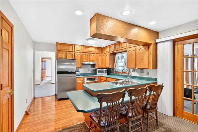 a kitchen with stainless steel appliances granite countertop table chairs and a large window