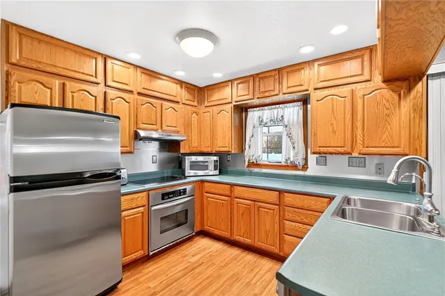 a kitchen with stainless steel appliances granite countertop a sink stove and refrigerator