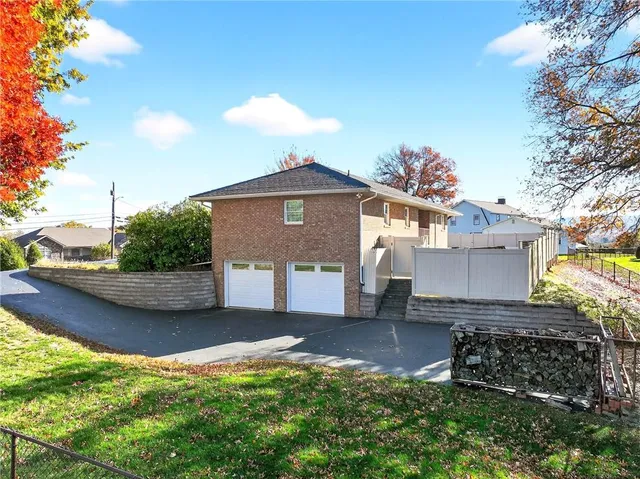 a front view of a house with a yard and potted plants