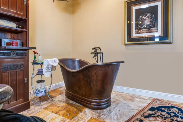 a room with painting on the wall and a rug