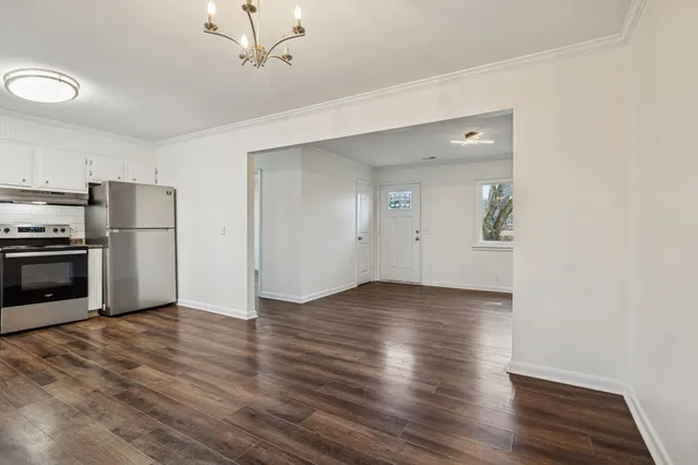 a view of a kitchen with wooden floor electronic appliances and window