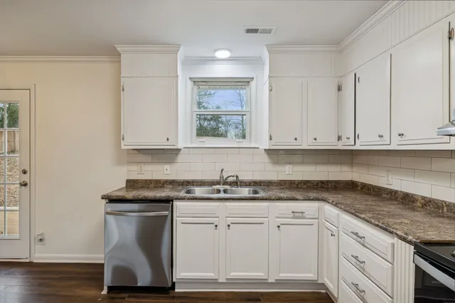 a kitchen with granite countertop white cabinets and white appliances
