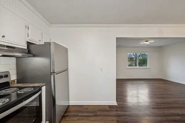 a kitchen with a refrigerator and a stove top oven