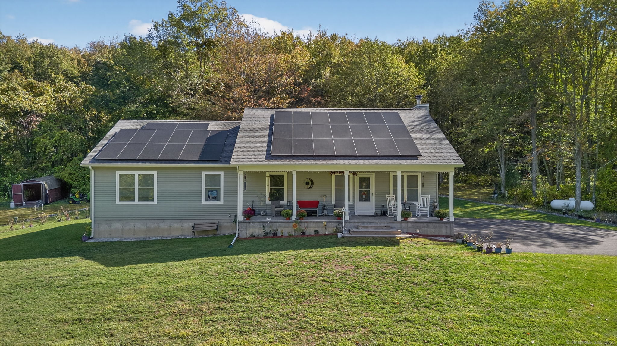 a front view of house with yard and trees in the background