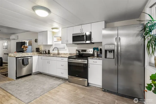 a kitchen with a sink stainless steel appliances and white cabinets