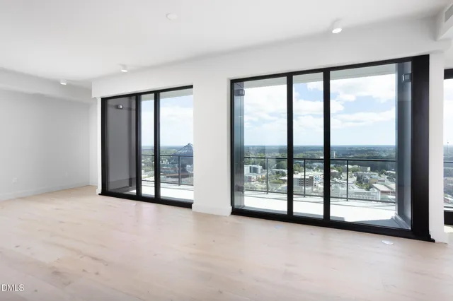 an empty room with sliding glass door and tree