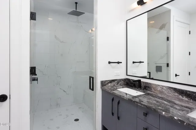a bathroom with a granite countertop sink a toilet and shower