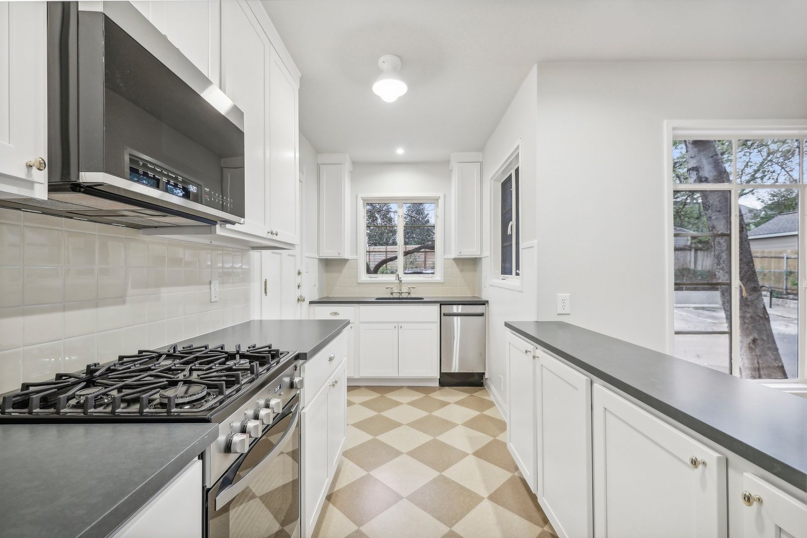 a kitchen with stainless steel appliances granite countertop a sink stove and cabinets