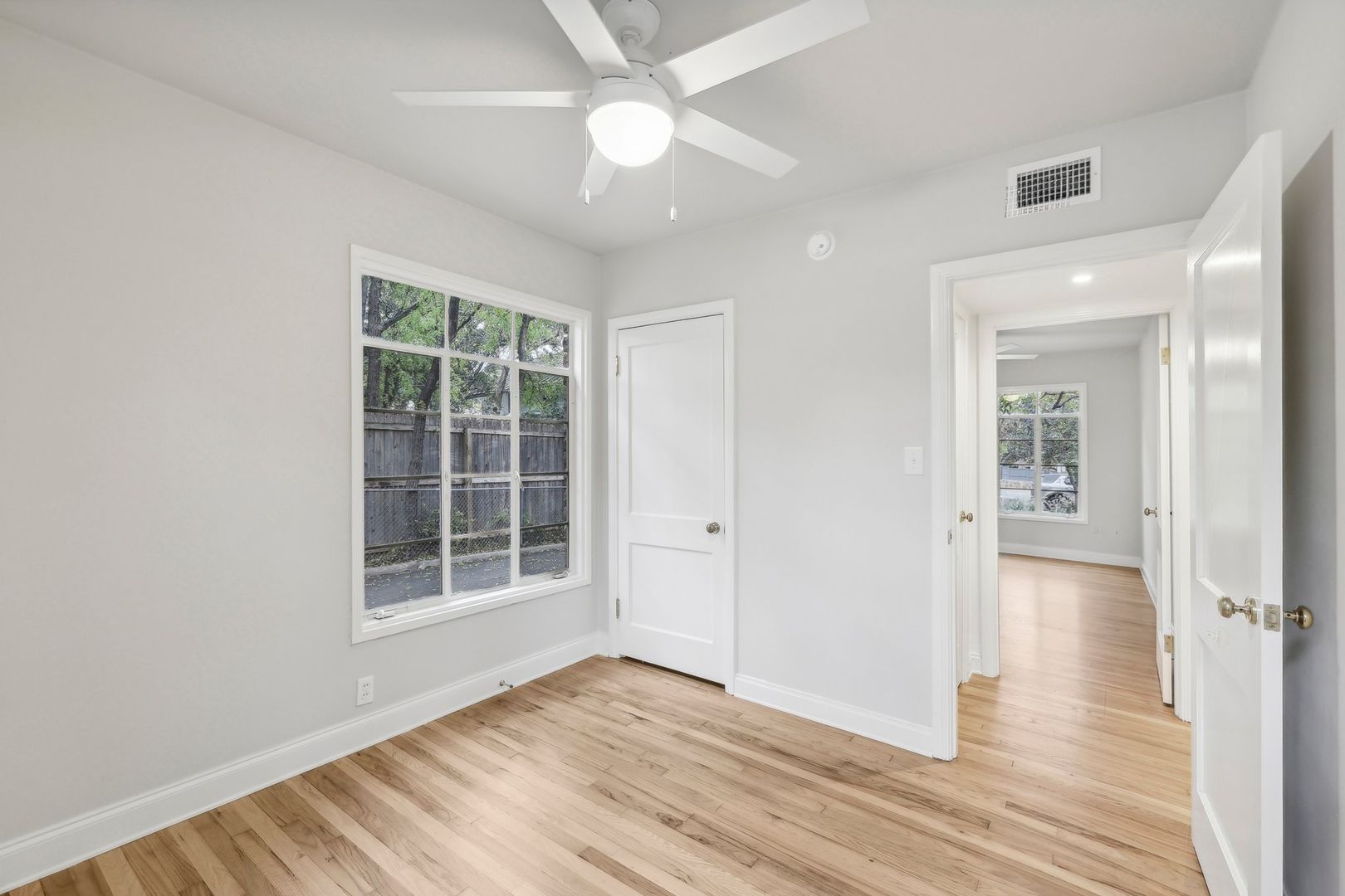 3010 Windsor Road, Unit E Austin, TX 78703 - Photo 11 of 17 a view of empty room with wooden floor and fan