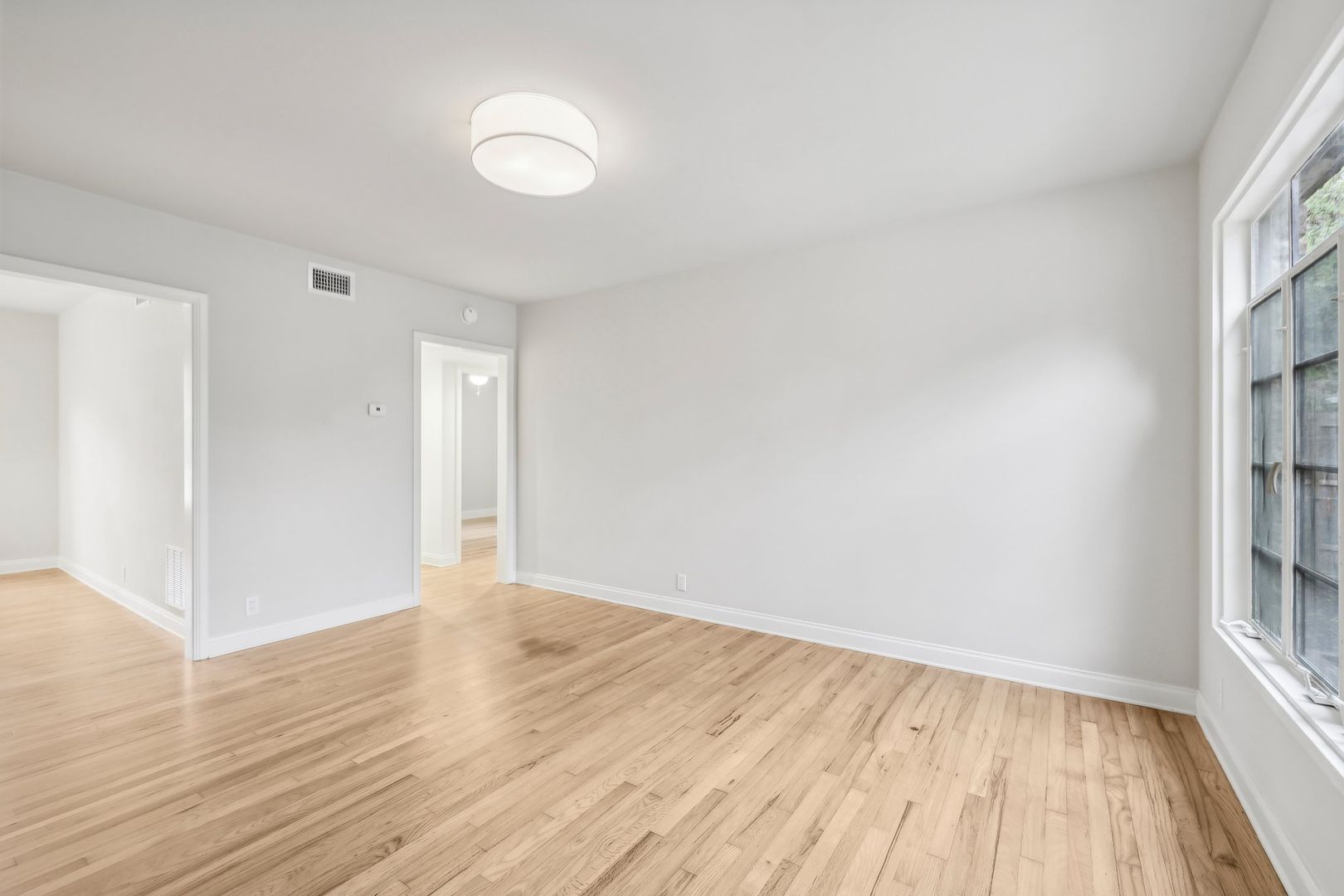 3010 Windsor Road, Unit E Austin, TX 78703 - Photo 14 of 17 a view of an empty room with wooden floor and a window