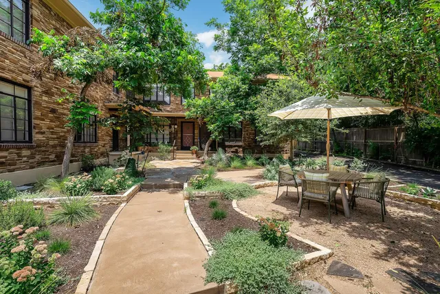 a view of backyard with outdoor seating and trees