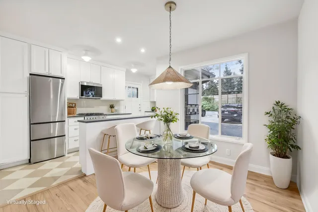 a kitchen with a dining table chairs and refrigerator