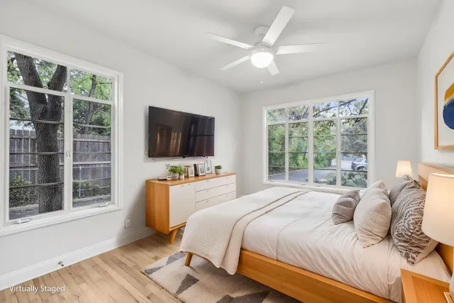 a bedroom with a bed and a flat tv screen on dresser