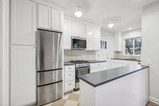 a kitchen with appliances a refrigerator and a sink