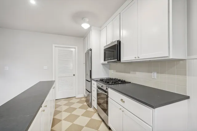 a kitchen with stainless steel appliances white cabinets and a stove