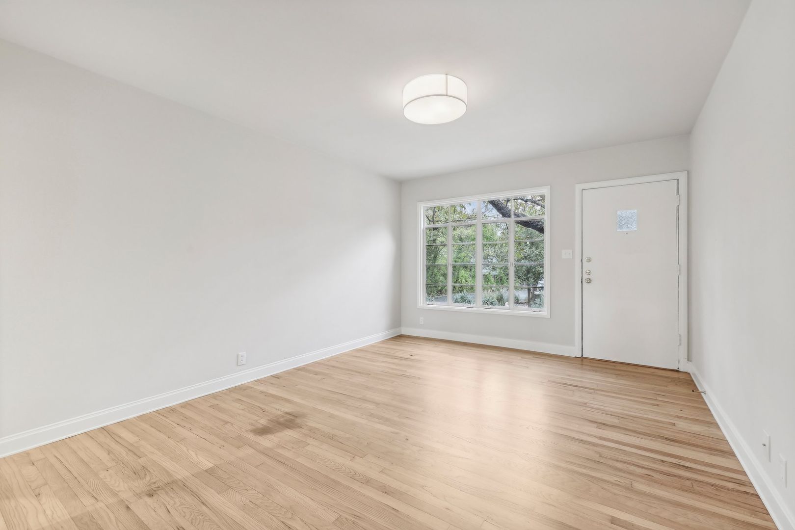 3010 Windsor Road, Unit E Austin, TX 78703 - Photo 9 of 17 a view of an empty room with wooden floor and a window