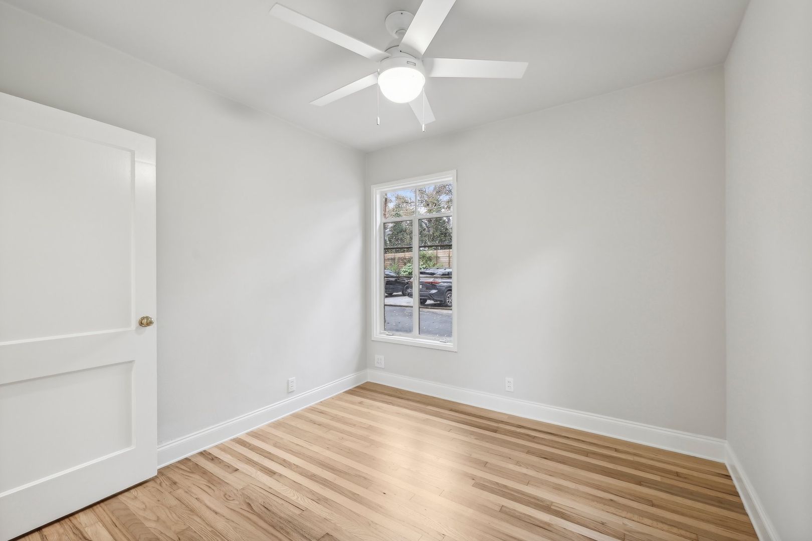 3010 Windsor Road, Unit E Austin, TX 78703 - Photo 10 of 17 an empty room with wooden floor fan and windows