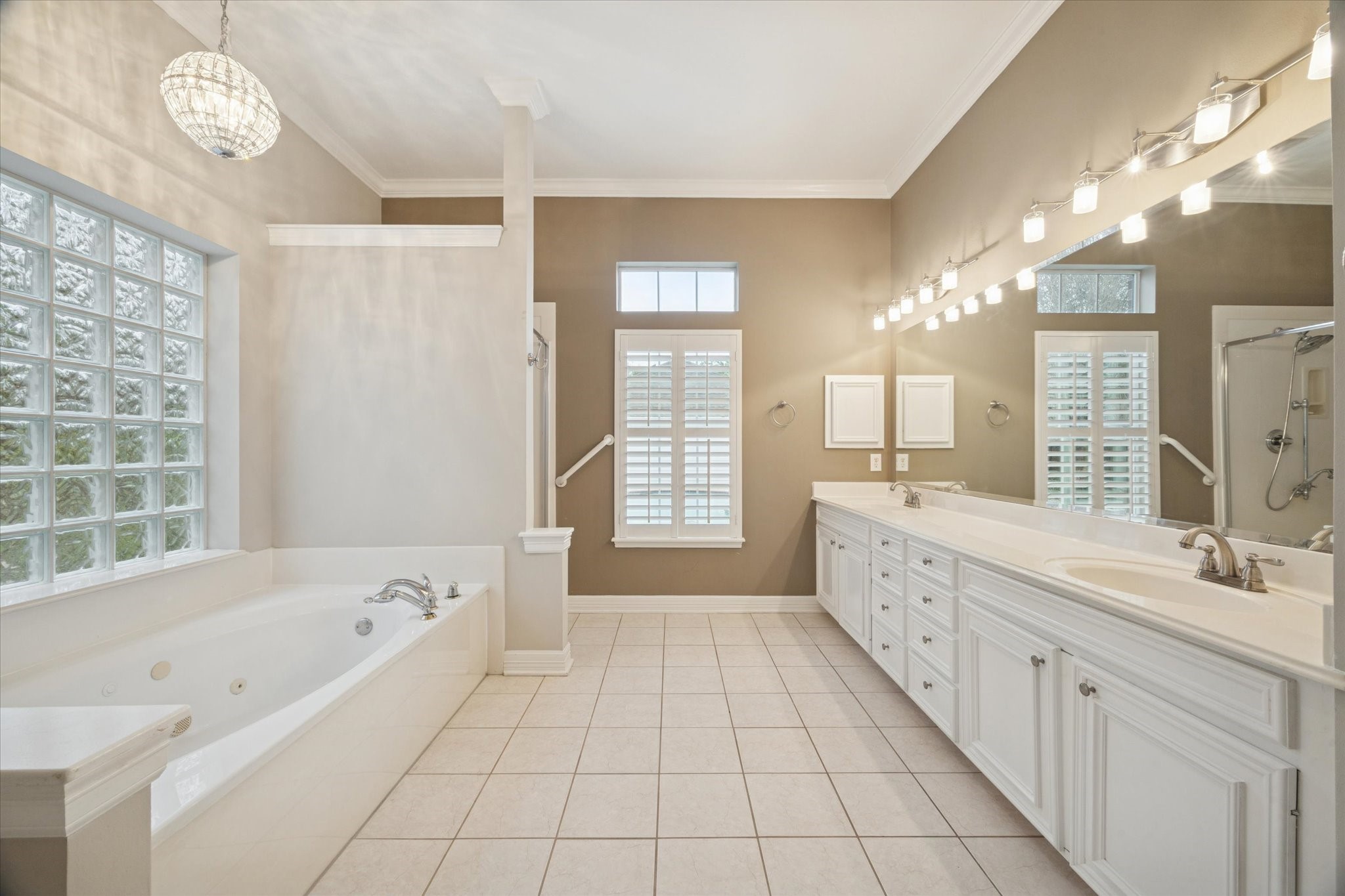 304 Scenic View Friendswood, TX 77546 - Photo 31 of 41 Primary bath is well lit with natural light and lovely fixtures. Double sinks and jetted tub make this space feel like a spa!