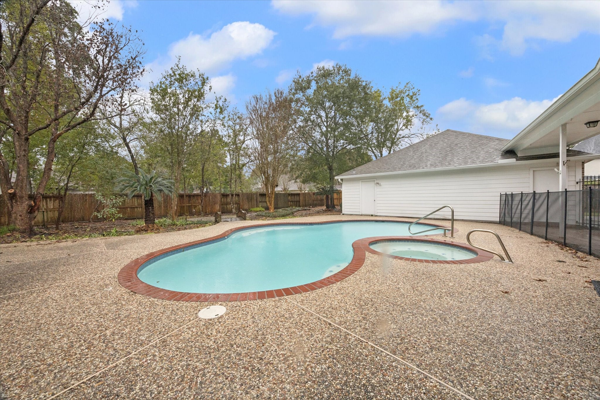 304 Scenic View Friendswood, TX 77546 - Photo 37 of 41 The pool was recently resurfaced and has a hot tub and safety fence.