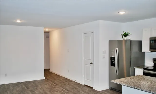 a view of hallway with kitchen island and wooden floor
