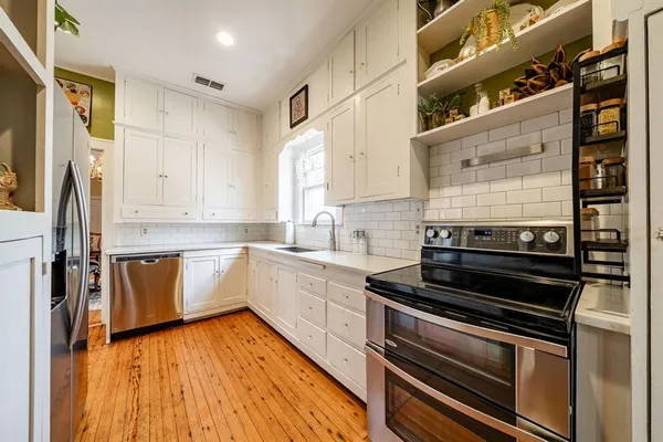a kitchen with wooden floors and appliances
