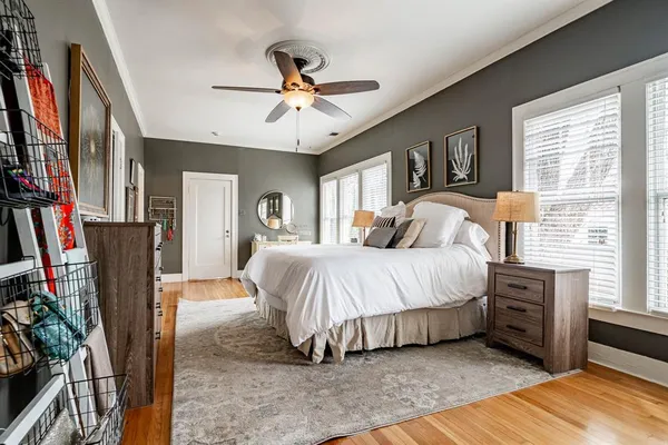 a bedroom with a large bed a flat tv screen and a chandelier