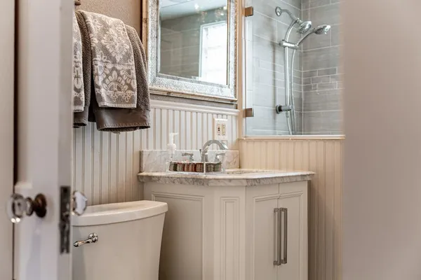 a bathroom with a sink a toilet and a mirror