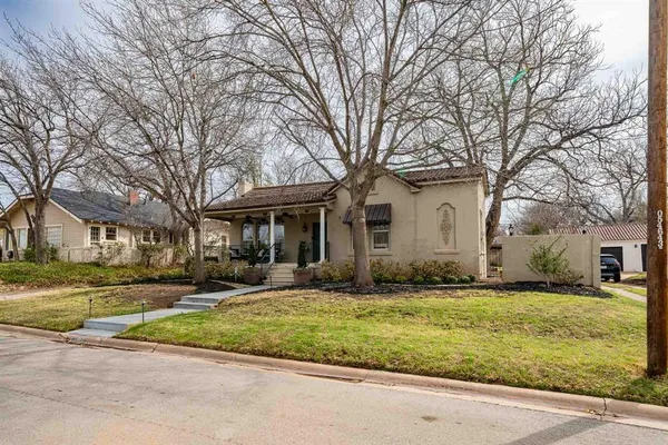 a view of a white house with a big yard and large trees