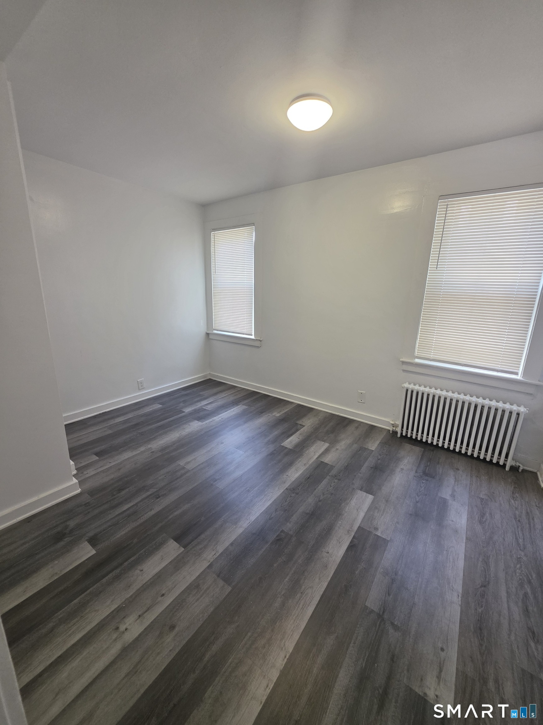 8 Mannz Street Hartford, CT 06114 - Photo 18 of 22 an empty room with wooden floor and windows