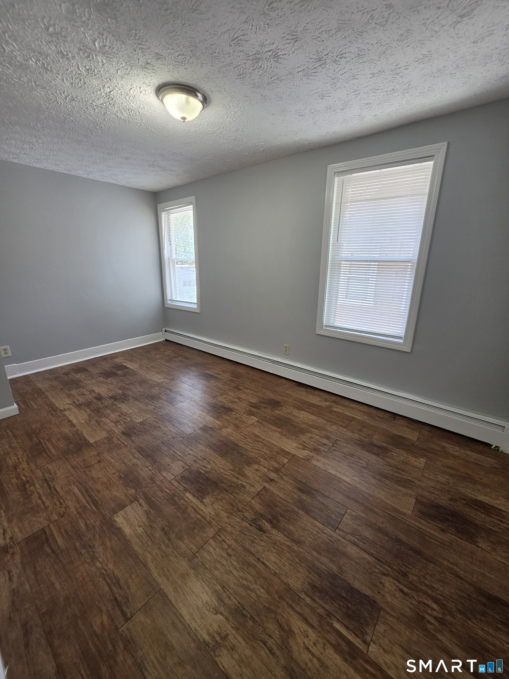 8 Mannz Street Hartford, CT 06114 - Photo 7 of 22 an empty room with wooden floor and windows