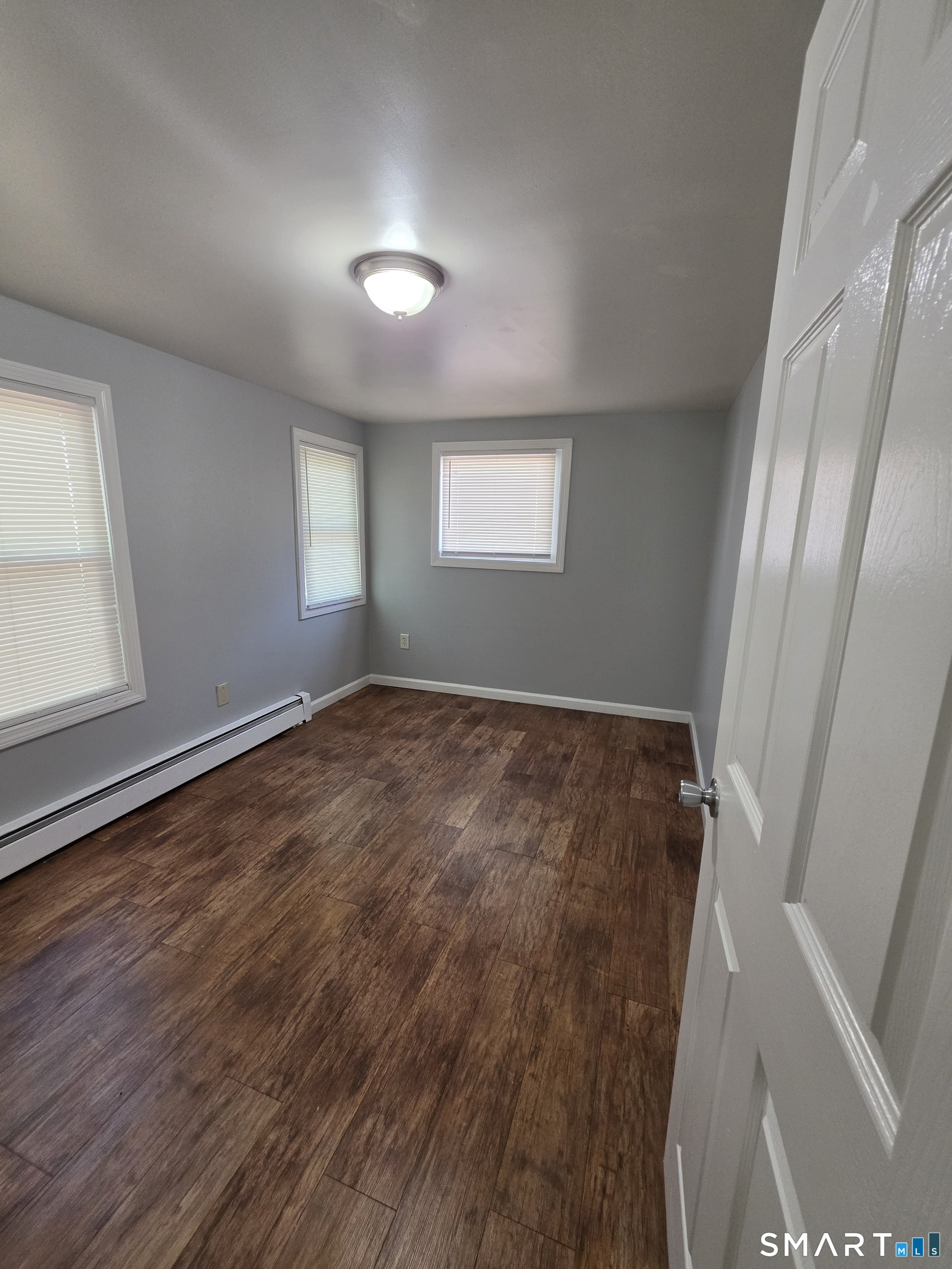 8 Mannz Street Hartford, CT 06114 - Photo 9 of 22 an empty room with wooden floor and windows
