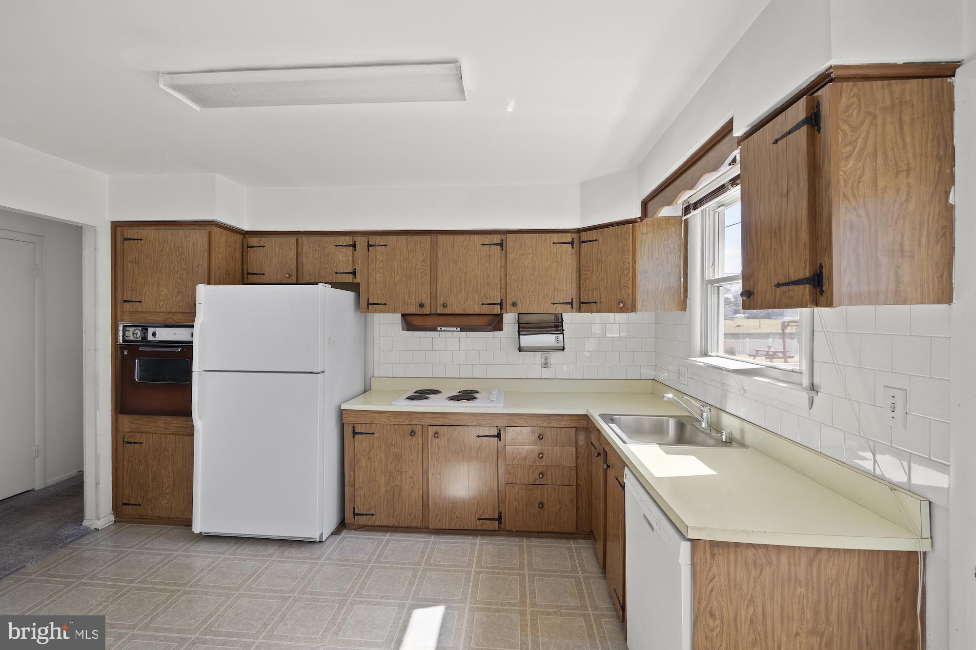 8605 Lucerne Road Randallstown, MD 21133 - Photo 11 of 30 a kitchen with a sink a stove and refrigerator