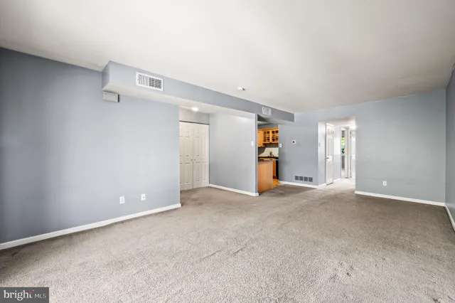 an empty room with closet and windows