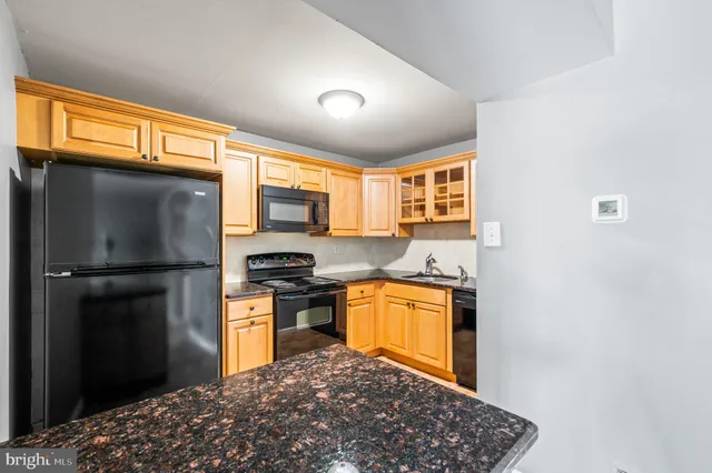 a kitchen with stainless steel appliances granite countertop a refrigerator a stove a sink and a microwave